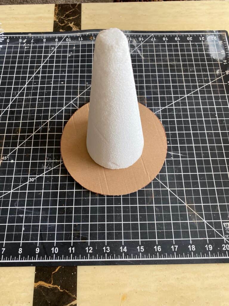 A foam cone glued to the center of a circle of cardboard base.
