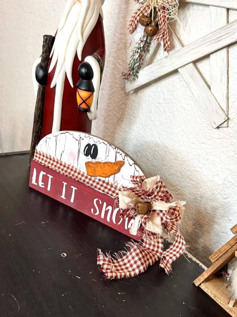 Tall vintage looking santa statue, rustic christmas paint stick star hanging on the wall, staged with the completed snowman project sitting on a bookshelf.