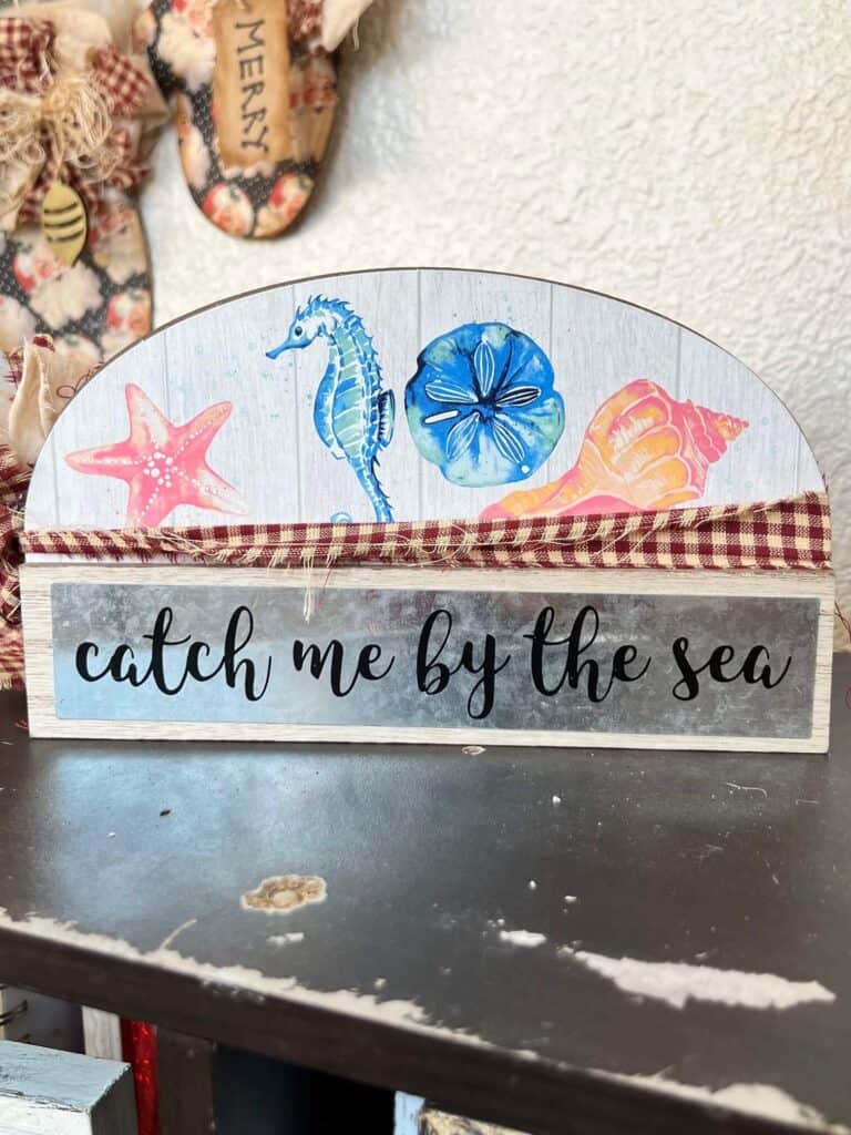 Dollar Tree decor with beach characters and a metal plate that says "catch me by the sea".