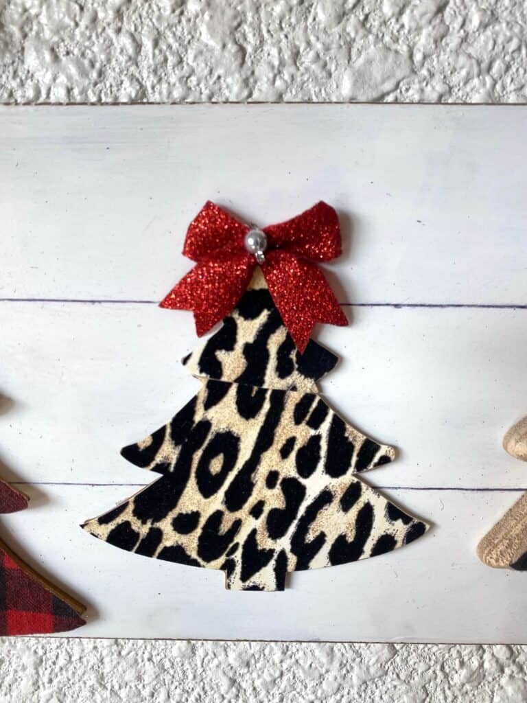 Leopard print Christmas tree with a mini red bow on top.