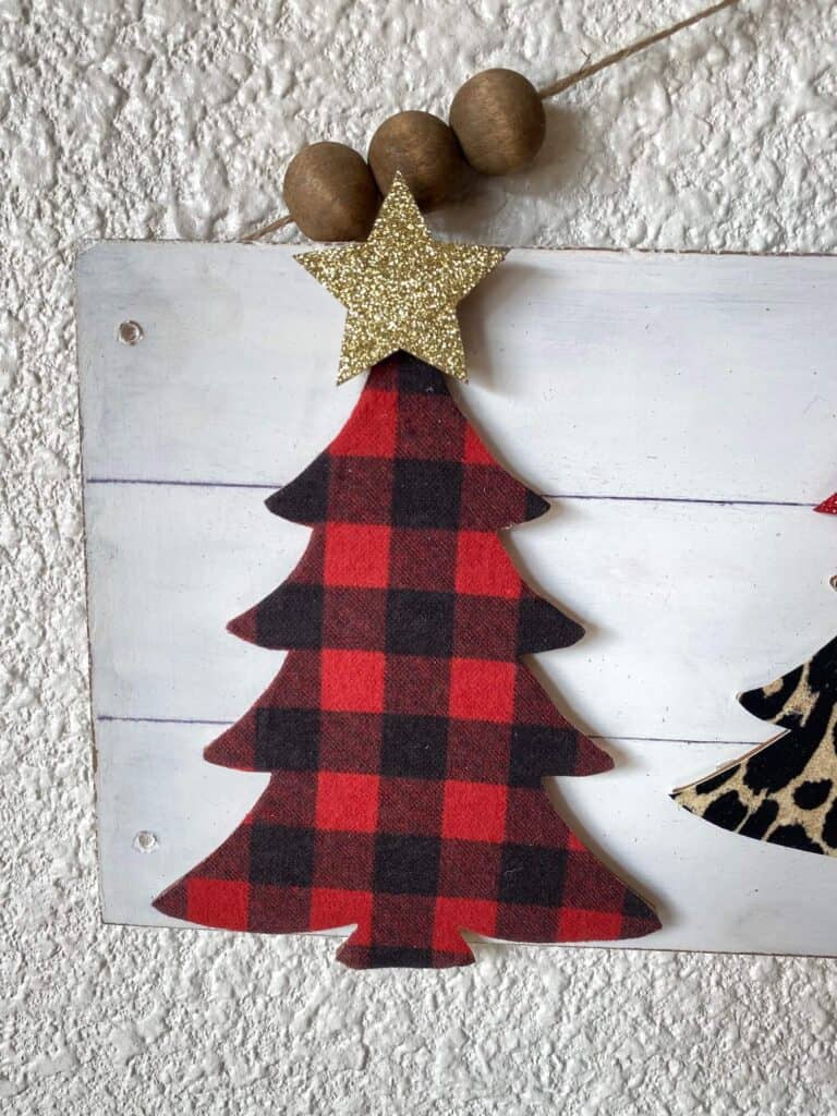 Red and black buffalo check christmas tree with a gold star on top.