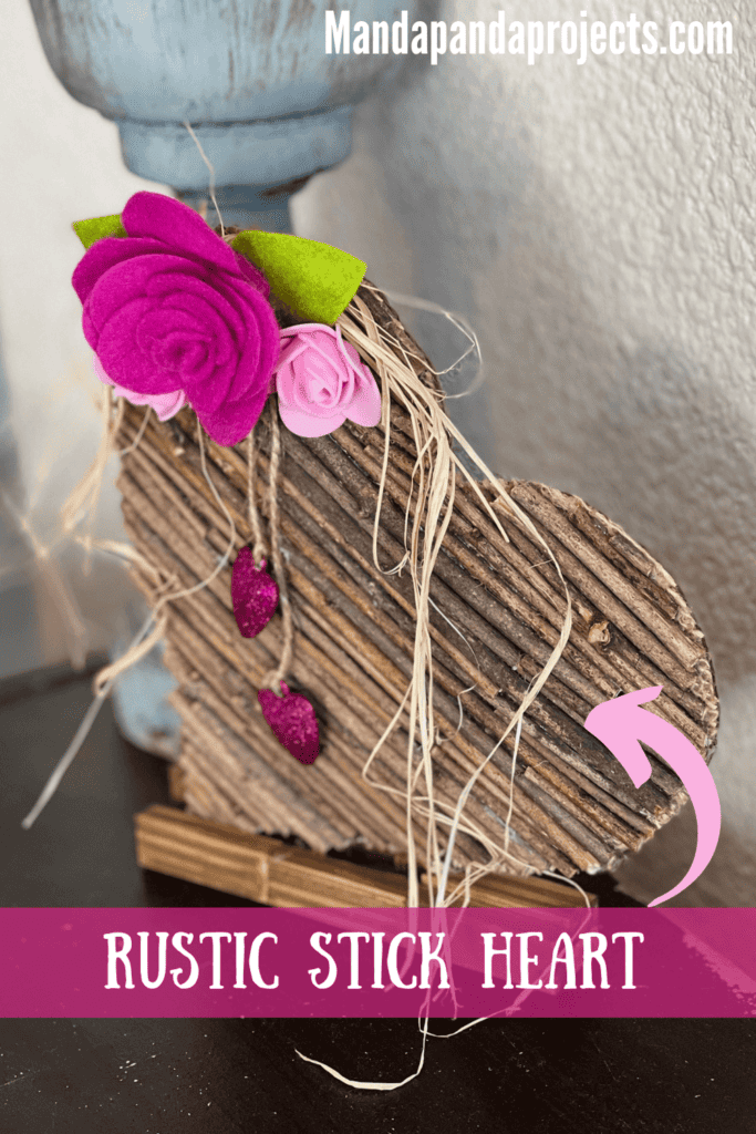 Rustic Valentines Day Stick Heart DIY Decor with felt roses and hanging pink sparkly hearts and raffia.