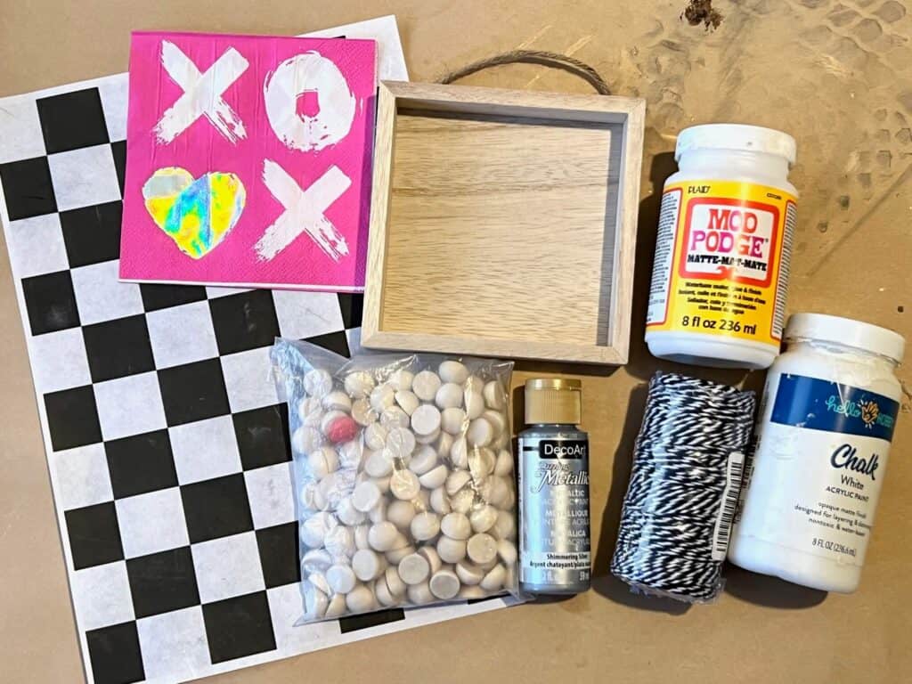 Supplies needed to make a tiered tray box frame with an XOXO napkin, black and white check rice paper and half wood beads.