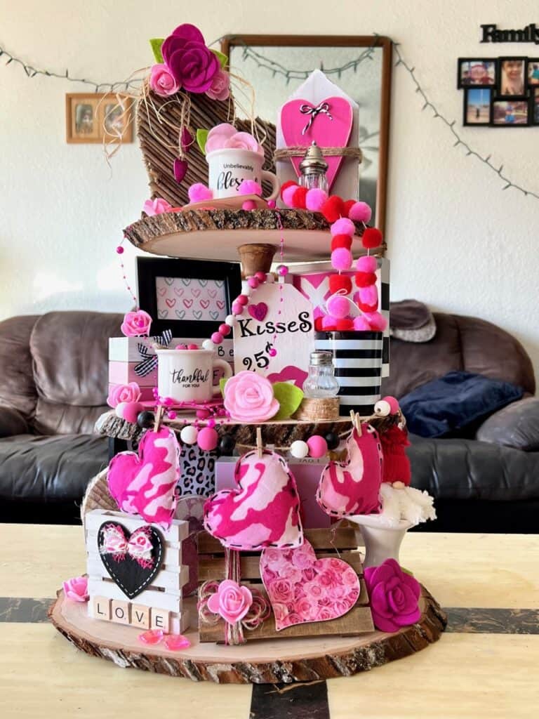 Rustic Valentines Day Tiered Tray Inspo on a handmade tray with pinks, reds, hearts, and packed with Valentines themed tiered tray miniatures and decor on all 3 tiers made of wood rounds.