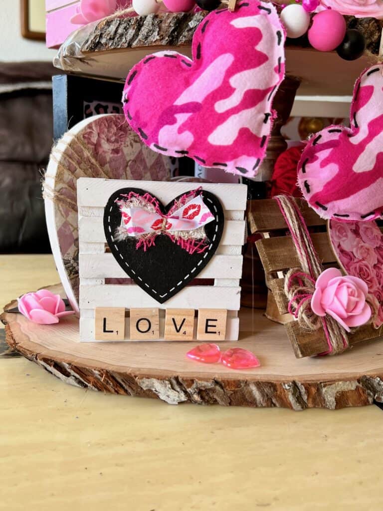 Mini white pallet with a black heart and the word LOVE in scrabble tiles.