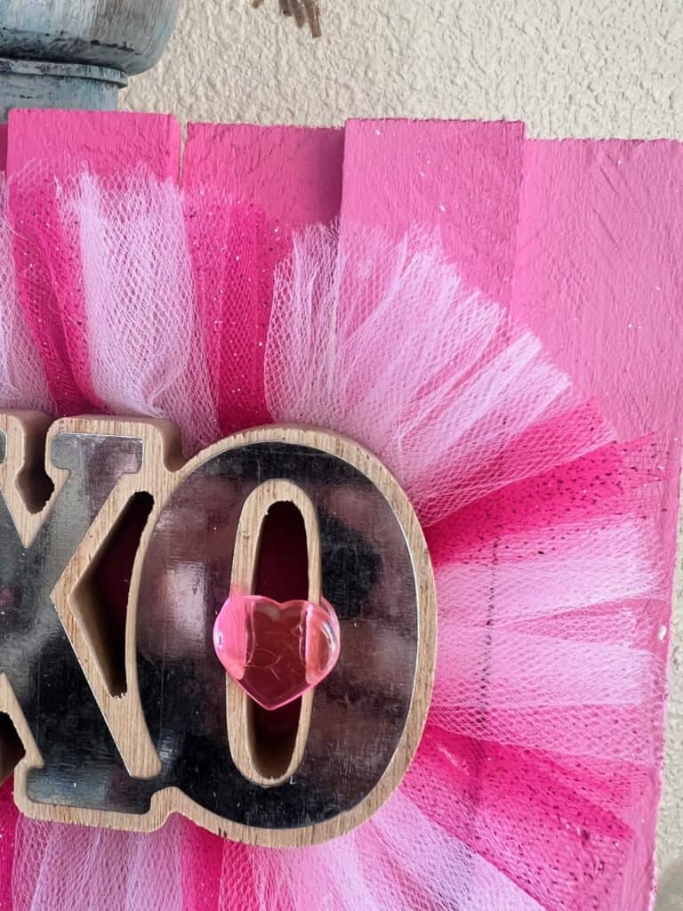 Pink glitter and white tulle glued around the XOXO word, with a pink heart embellishment in the middle of the O.
