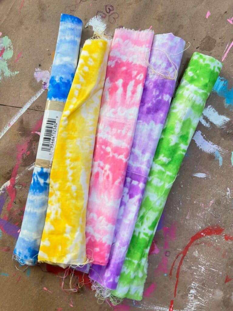 5 rolls of dollar Tree fabric, from left to right, blue, yellow, pink, purple, green.