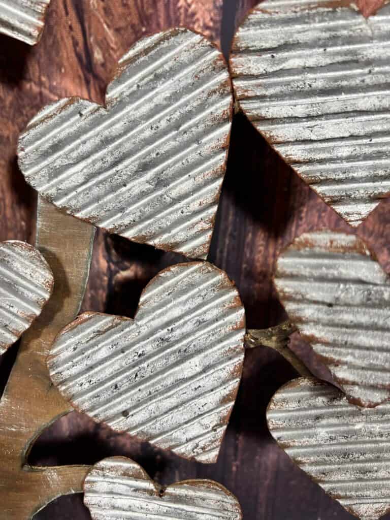 Closeup of the corrugated cardboard hearts made to look like galvanized metal with rust around the edges,