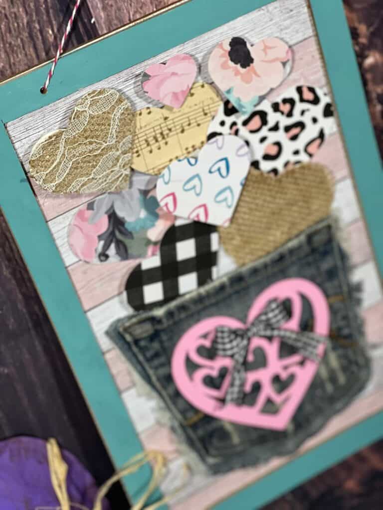 Close up of the floating burlap, lace, and scrapbook paper hearts coming out of the jeans pocket.