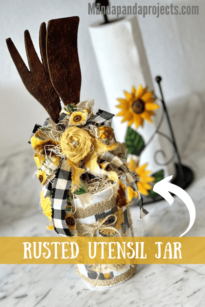 Rusted Utensil Kitchen Jar DIY Decor made with thrift store wood fork and spoon, vintage sunflower rice paper printable, burlap, buffalo check and a scrappy fabric bow for a Sunflower theme kitchen.