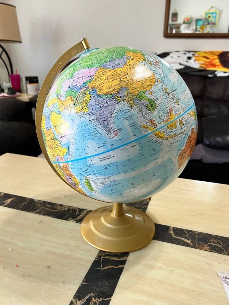 A thrift store globe before it was painted and decoupaged or upcycled.