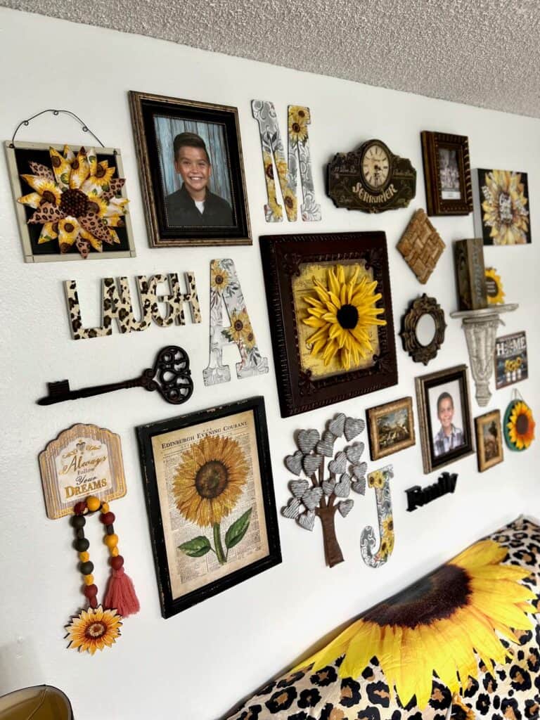 Sunflower themed gallery wall with leopard print accent pieces, designed with thrifted, unique, handmade decor that makes a bright and cheery vibe in a living room.