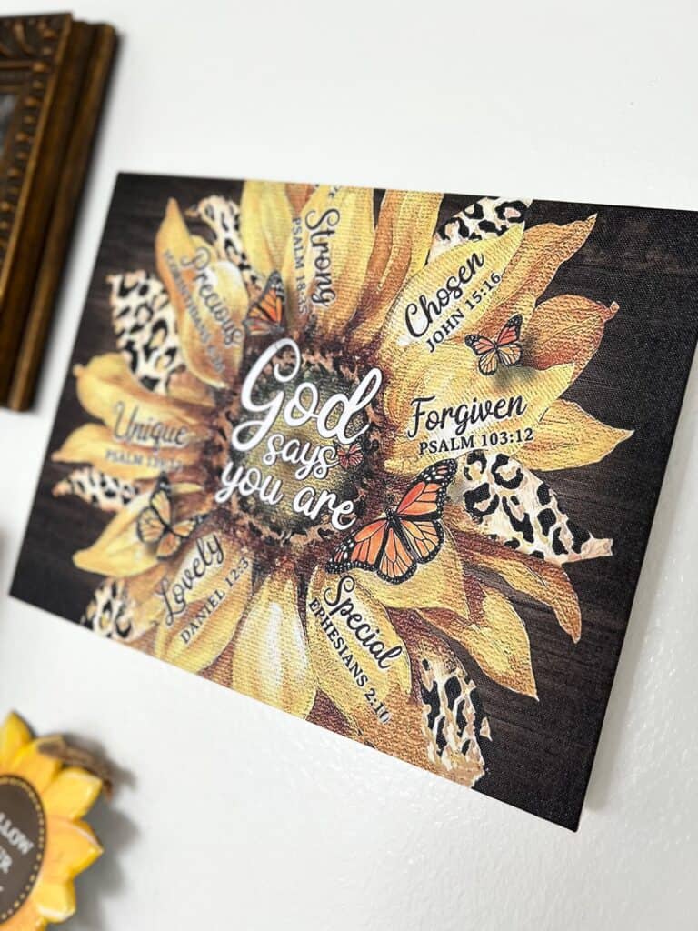 A large sunflower canvas with leopard print petals that says "God Says you are..."