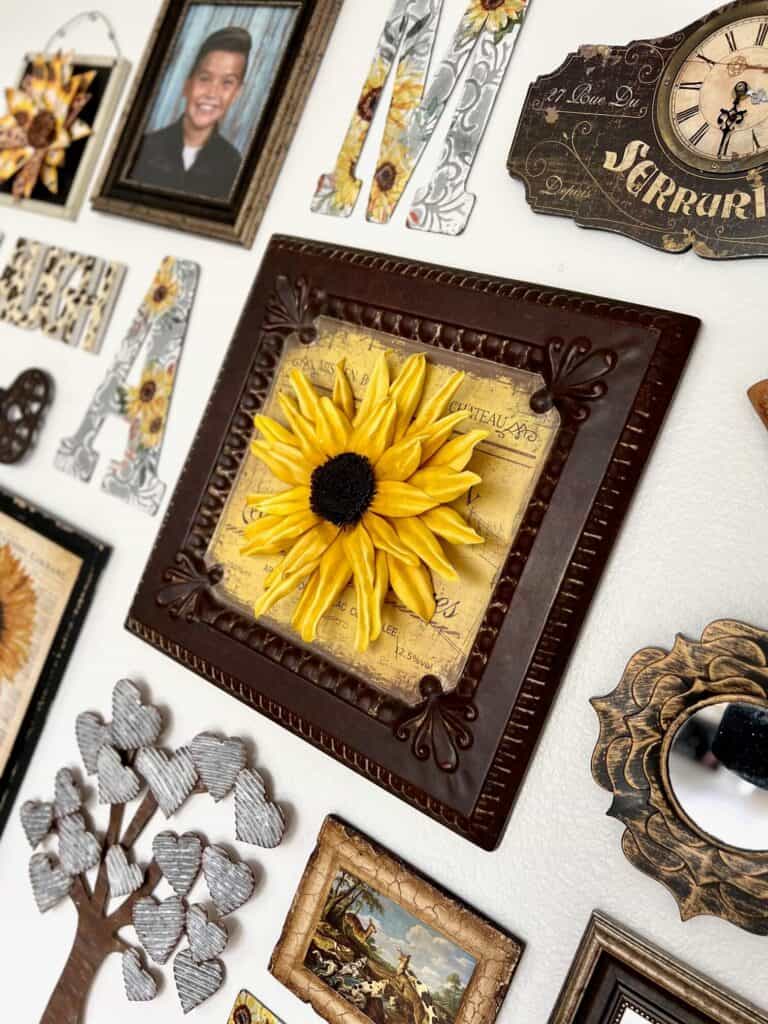 The main focal point of the gallery wall which is the huge foam sunflower on a large tin frame.