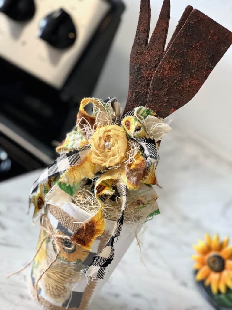 Rusted Utensil Kitchen Jar DIY Decor made with thrift store wood fork and spoon, vintage sunflower rice paper printable, burlap, buffalo check and a scrappy fabric bow for a Sunflower theme kitchen.