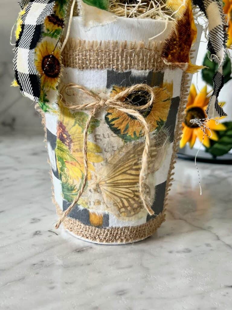 The base of the jar with burlap, black and white checks paper, sunflower paper, and a small twine bow.