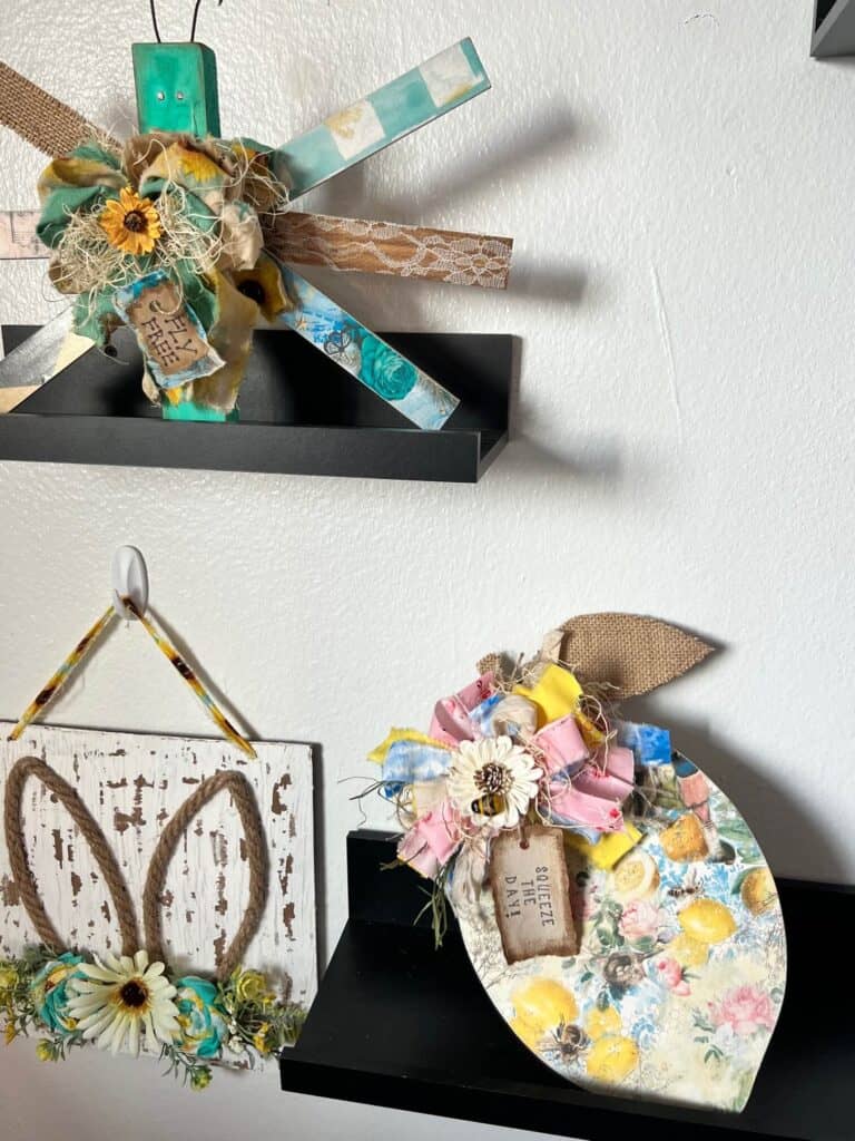 The completed summer lemon decor sitting on a shelf with a paint stick butterfly and a spring floral decor.