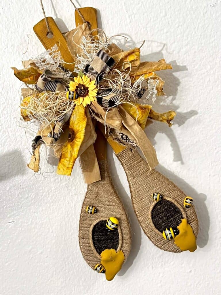 Dollar Tree Wood Spoon Beehives easy and affordable DIY summer decor for a bee and sunflower theme decoration with a bug messy bow, twine and honey.