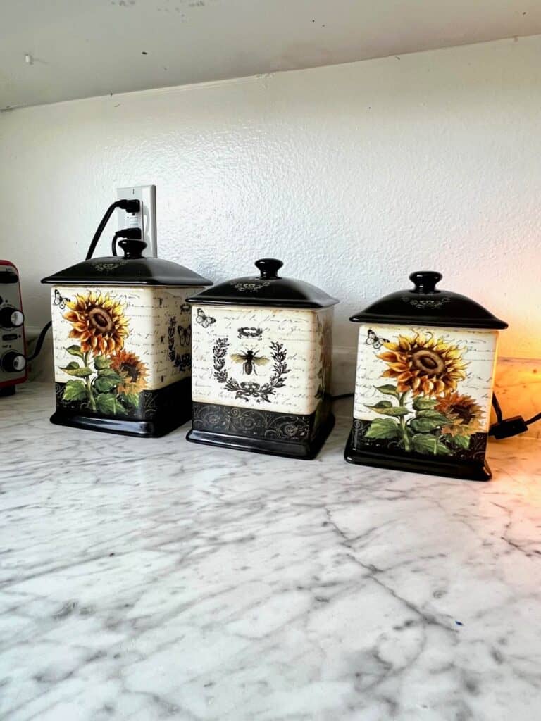 Sunflower canisters with bees and butterflies on the kitchen counter.