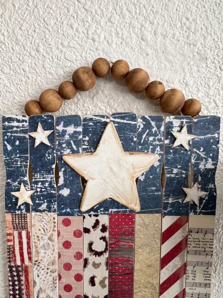 The top of the flag showing the blue scrapbook paper and the white wood stars.