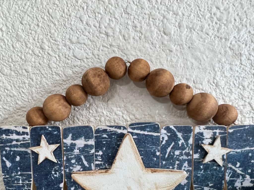 The wood bead hanger on top of the american flag.
