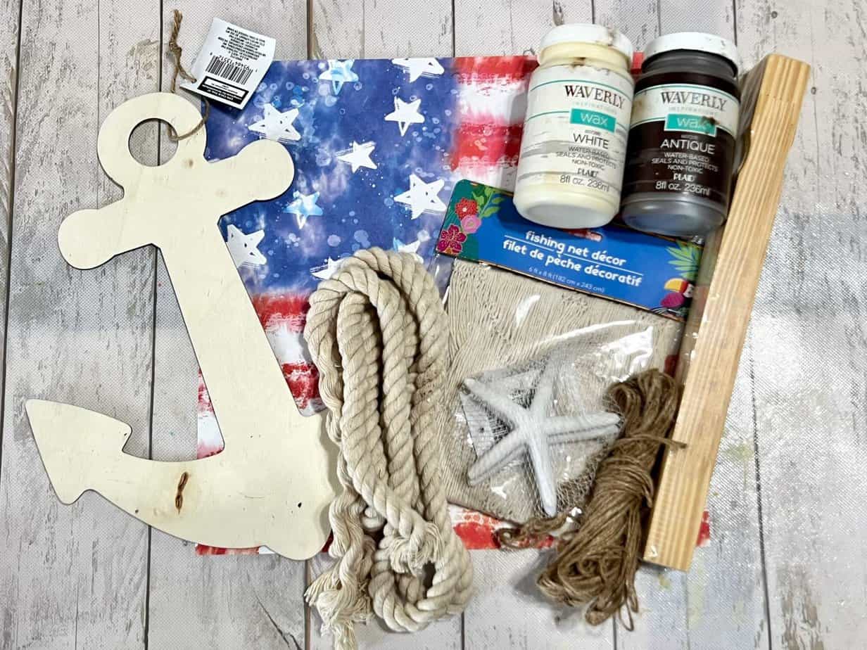 Supplies needed to make a patriotic anchor with a dollar tree wood anchor and american flag scrapbook paper.