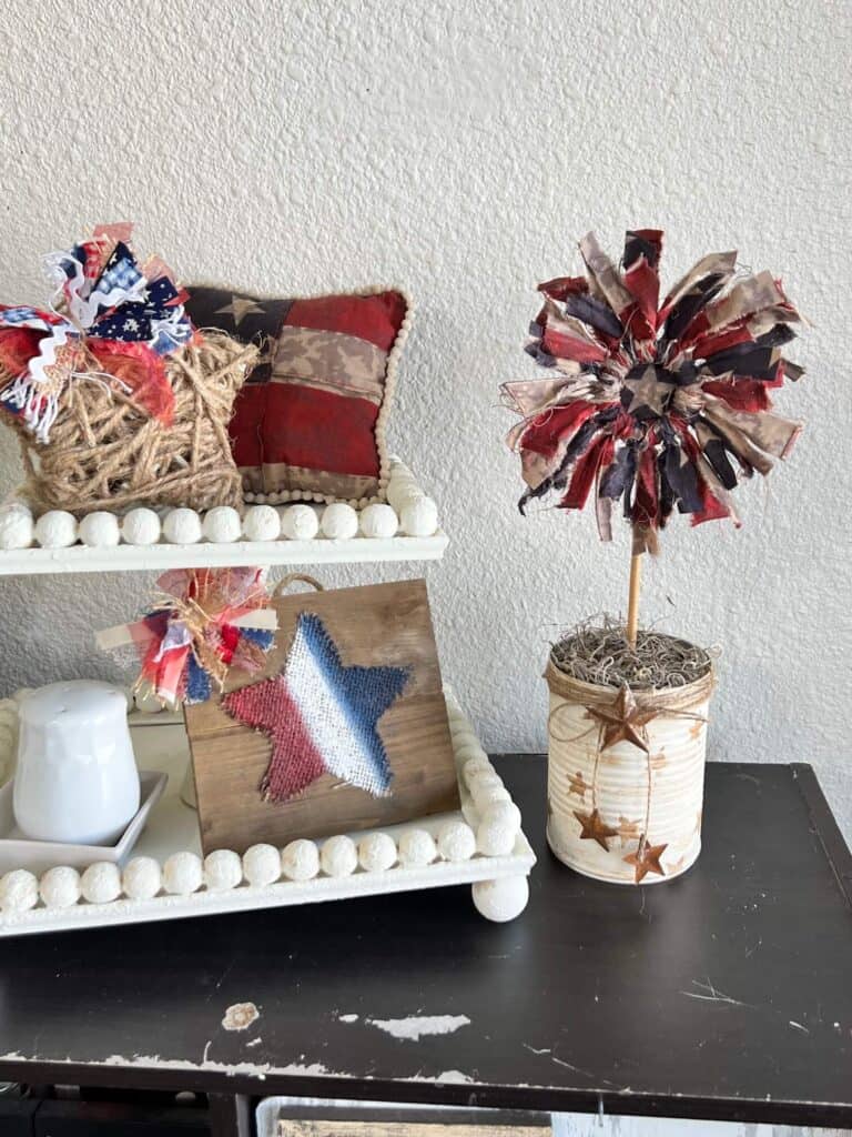Patriotic Fabric Flower on a bookshelf next to a white beaded 2 tiered tray.