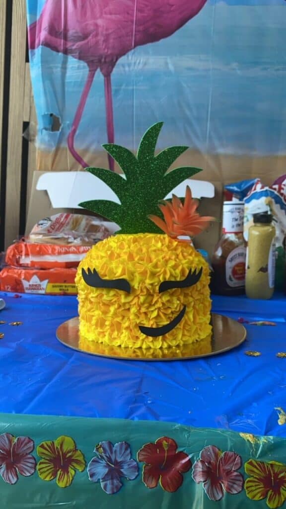 A pineapple themed cake with a face.