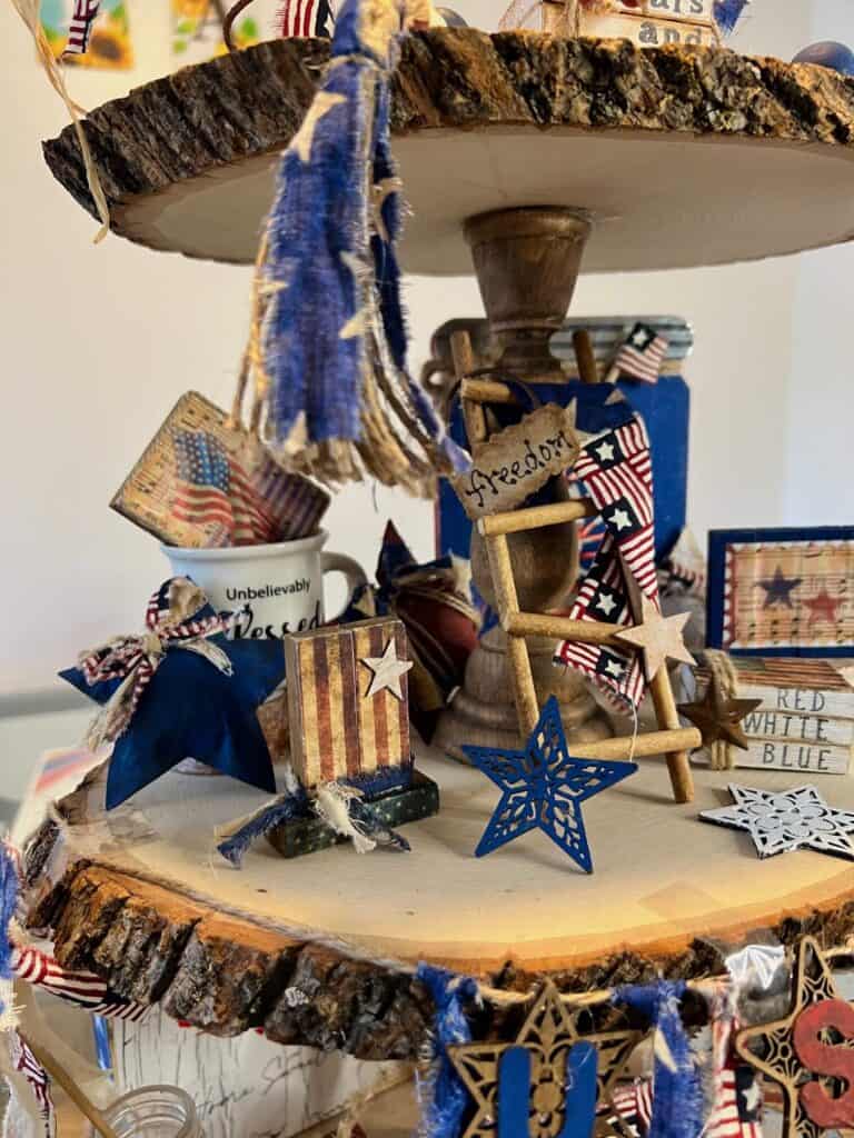 Close up of the left side of the middle tier showing the Patriotic Uncle Sam jenga block hat, kraft paper stars, and patriotic ladder.