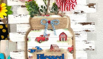 Patriotic Floral Mason Jar with wood cutout, vintage red, white, and blue truck and barn, stars and stripes dollar tree flowers on a white chippy shim background to decorate for the 4th of July or memorial day.