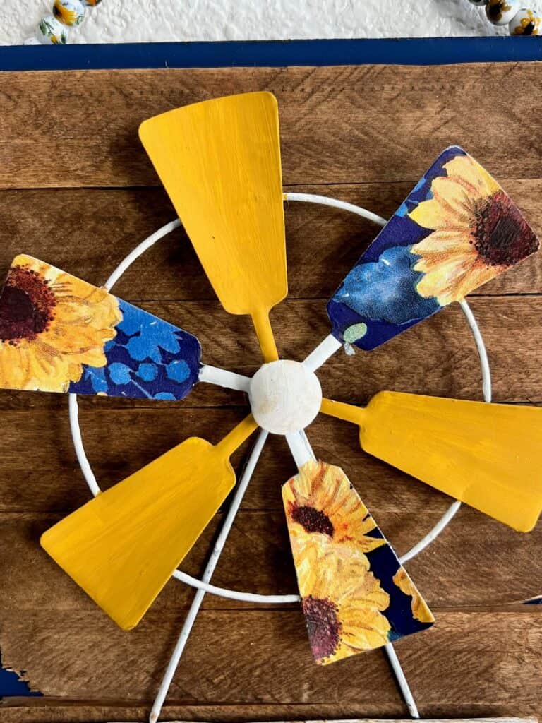 Close up of the windmill portion of the whole welcome sign with yellow blades and sunflower napkin blades.