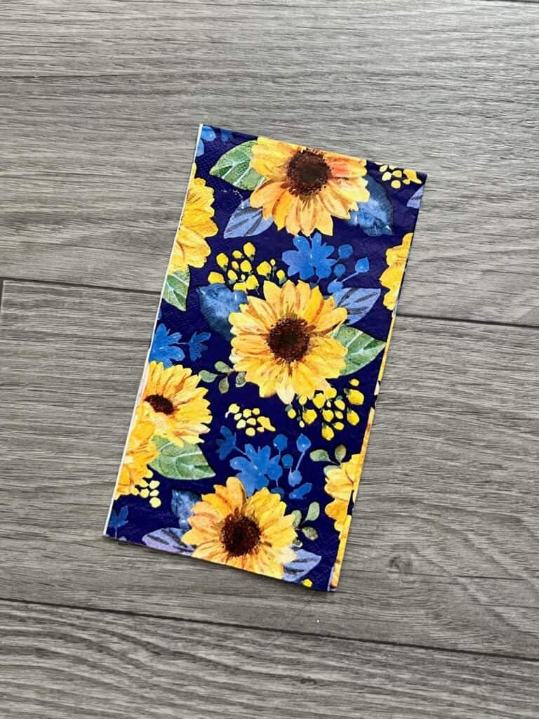 A sunflower napkin with navy blue background.
