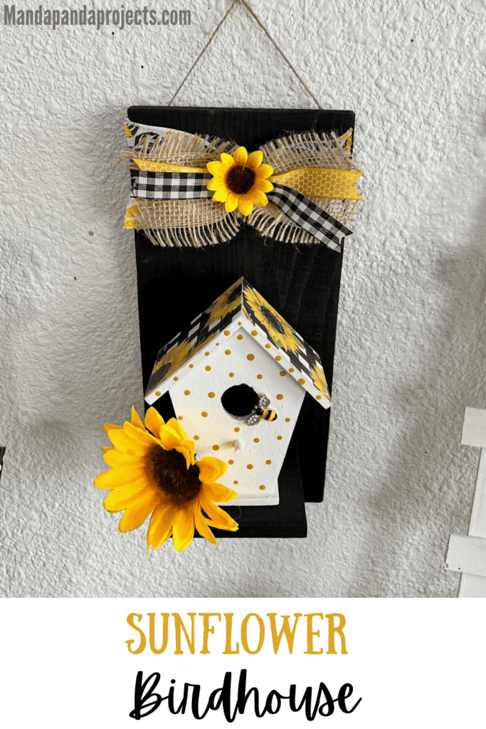 Sunflower Birdhouse Decor with a wood birdhouse, black wood background, sunflower scrapbook paper roof, and little yellow polka dots with a small burlap bow on the top.