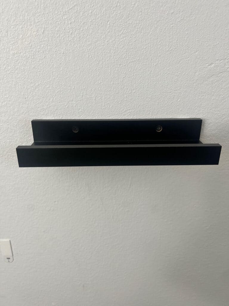 One black floating shelf hanging on the wall.