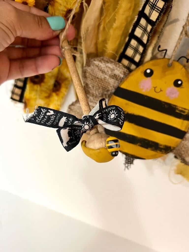 The honey dipper with a small black and white bow, a small bee, and honey made from Hot glue.