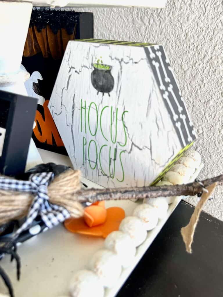 A Hocus Pocus hexagon shelf sitter with green striped and bones scrapbook paper on the edges.