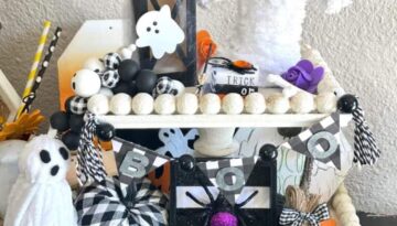 DIY Handmade Halloween Tiered Tray on a white wood bead 2 tiered tray with ghosts, spiders, witches broom, pumpkins, bones, frankenstien, mummy and other Halloween decor.