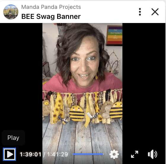 Amanda holding the completed bee sunflower swag banner on a Facebook live thumbnail.