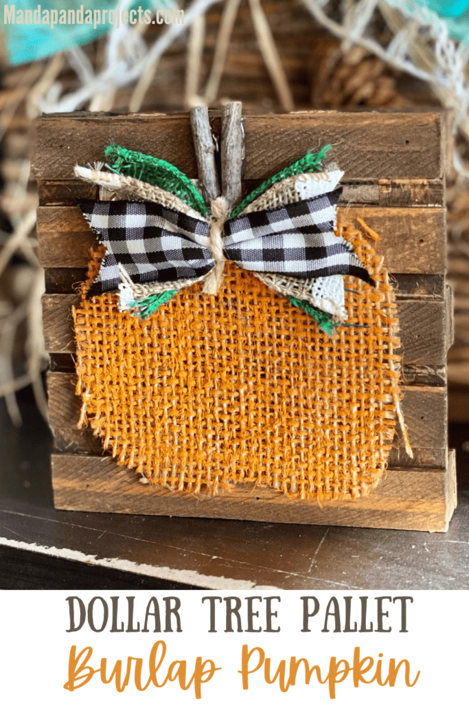 Mini Pallet Burlap Pumpkin with orange painted burlap, a stick stem, and a buffalo check bow on a mini dollar tree pallet that is stained brown with Antique wax.