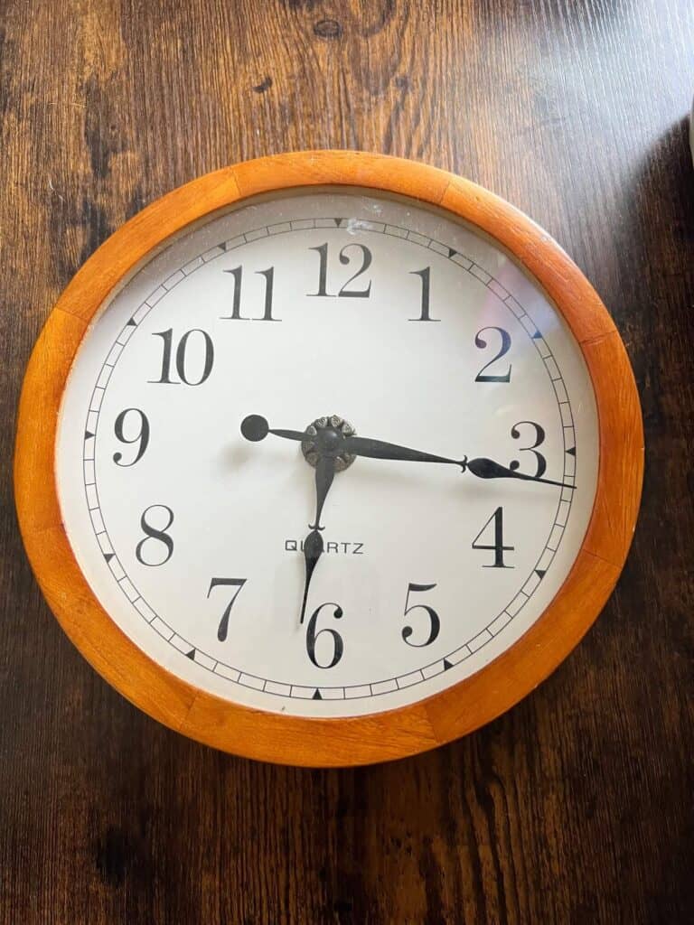 Thrift store clock, generic clock face with light brown outer rim.
