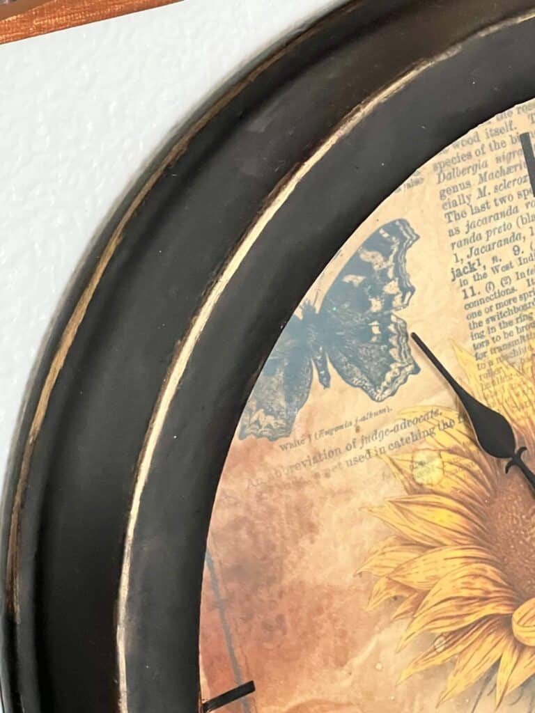 The outer edge of the clock, painted black with gold rub n' buff detail.