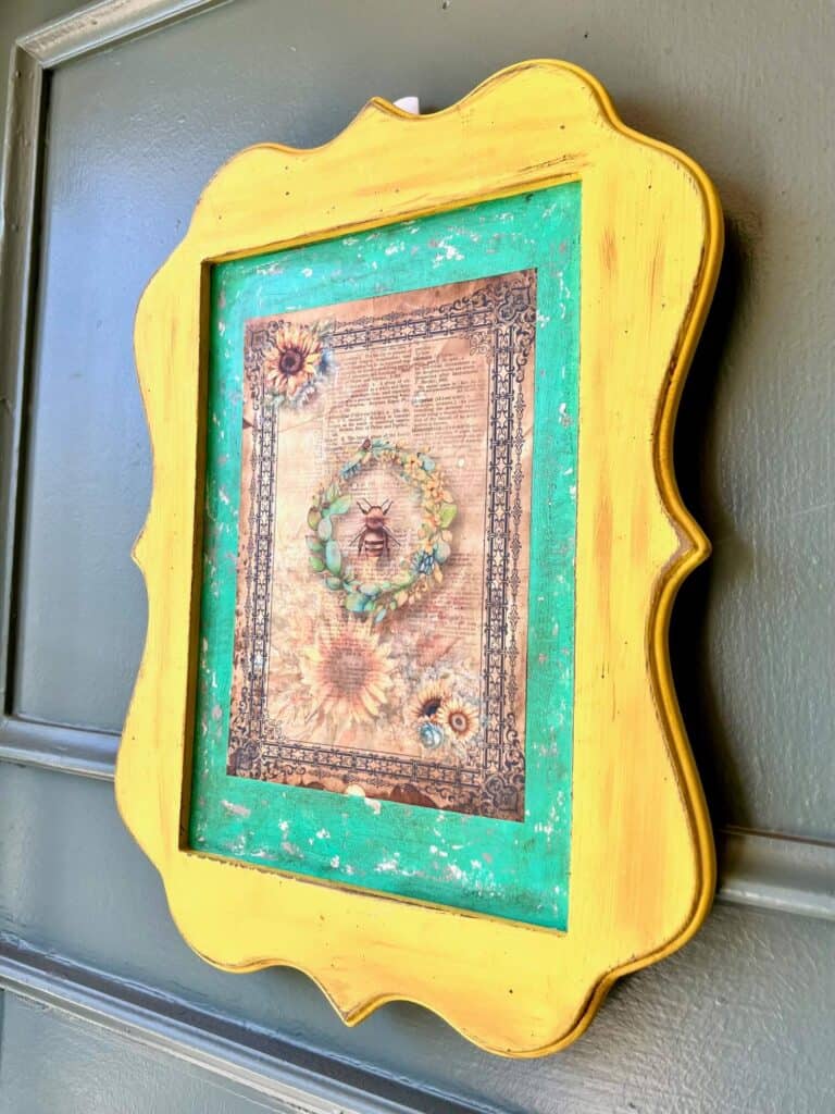 Thrift Store yellow Framed Sign Makeover with a chippy teal background and a Sunflower and Bee vintage vibe rice paper printable. DIY Home decor piece.