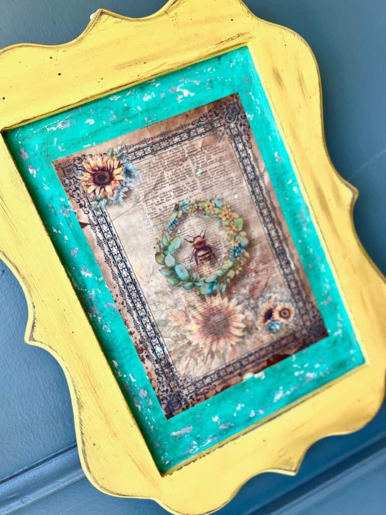 Thrift Store yellow Framed Sign Makeover with a chippy teal background and a Sunflower and Bee vintage vibe rice paper printable. DIY Home decor piece.