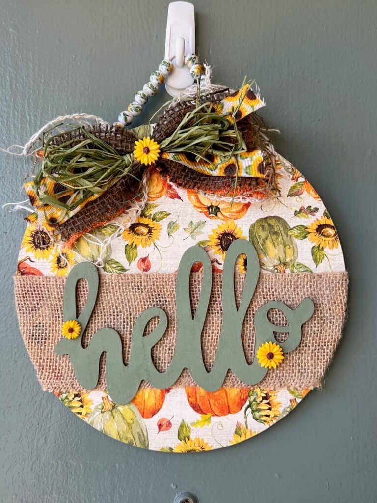 Dollar Tree Hellon round with a sunflower pumpkin napkin decoupaged to the wood round as a pretty background.