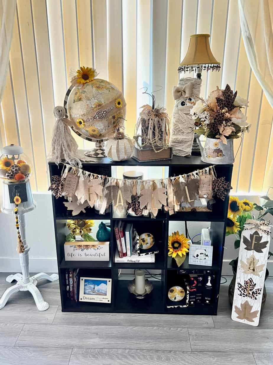 Neutral Fall-O-Ween Bookcase inspo to decorate for fall and halloween with DIY crafts and decor as well is thrift store finds with neutral, gold, leopard print, and vintage sunflower.