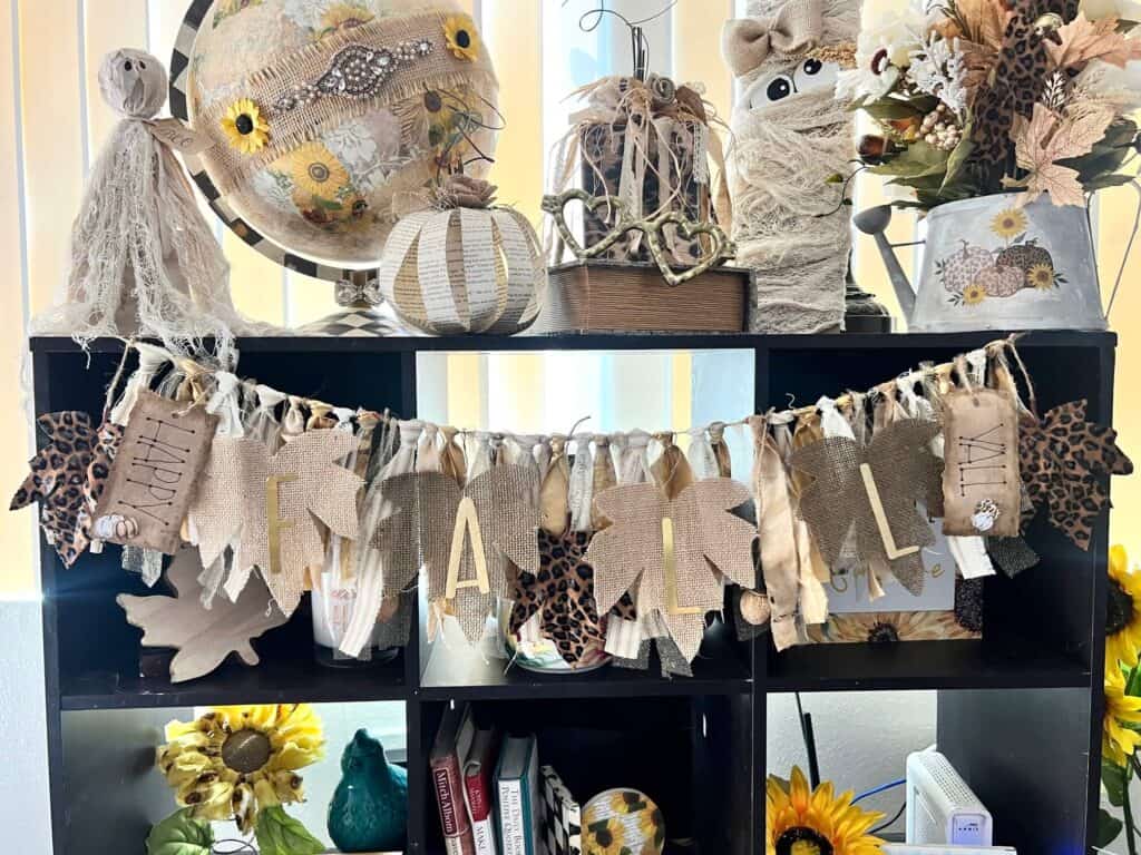 A Fall Swag Banner with leopard print leaves, neutral and gold fabric, that says "It's Fall Y'all".