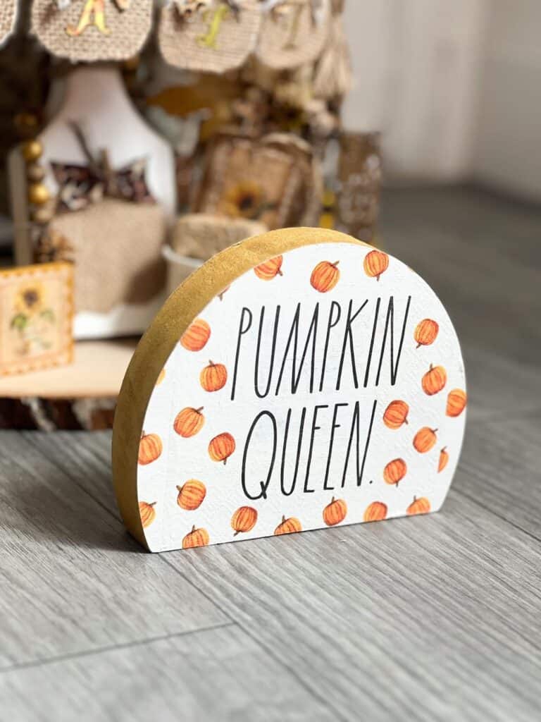 Pumpkin queen half circle shelf sitter with gold edges.