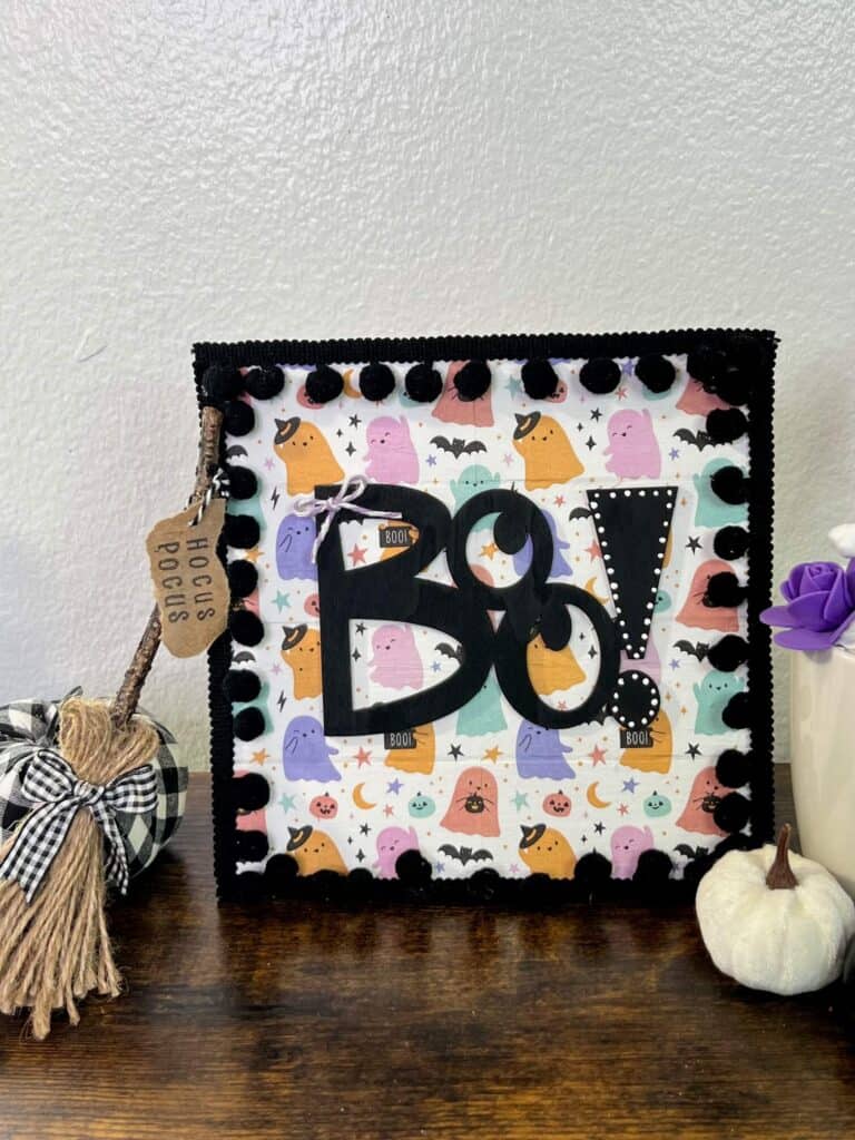 Dollar tree BOO napkin sign with cute pastel colored ghosts and black pom pom trim.