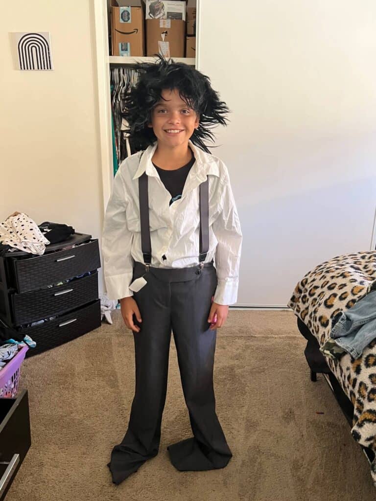 Maddox in the thrift store grey pants and white shirt with suspenders.