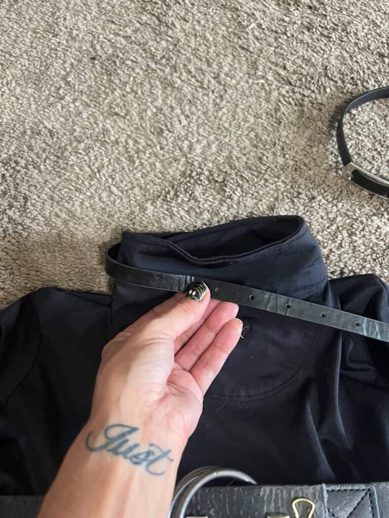 Thin black belt being glued to the collar of the black shirt.